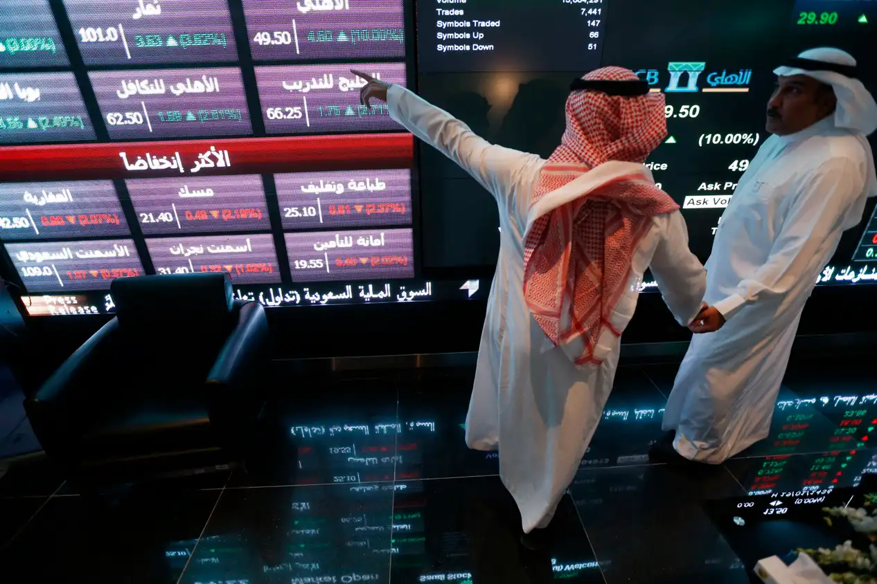 Investors talk in front of monitors at the Saudi Stock Exchange. Conglomerates and state-backed giants are preferred in many Gulf IPOs